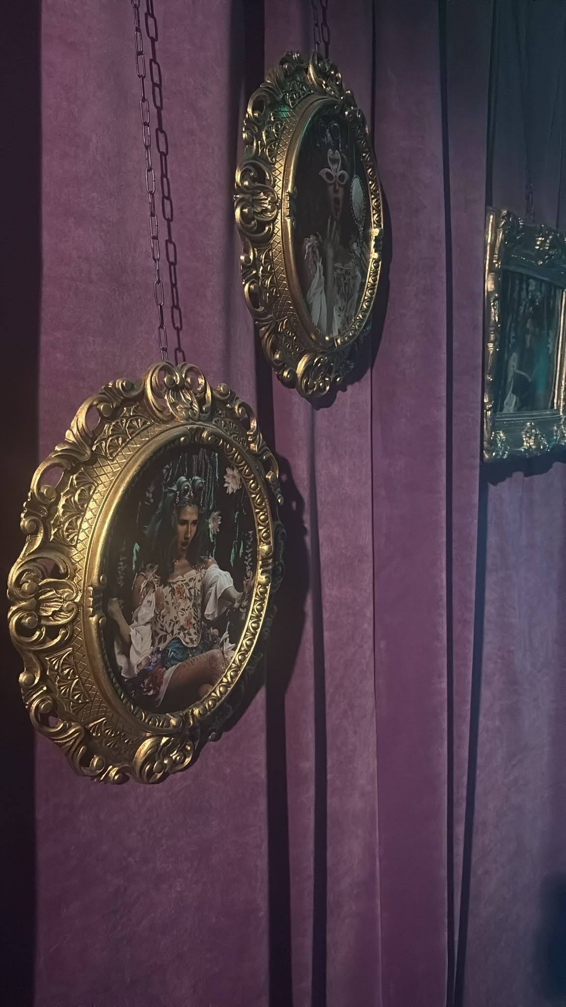 Scénographie de la Cité Immersive des Fables : cadres dorés suspendus sur velours