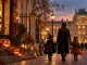 Halloween en famille à Paris : parent et enfants déguisés dans une rue parisienne illuminée aux couleurs de l'automne